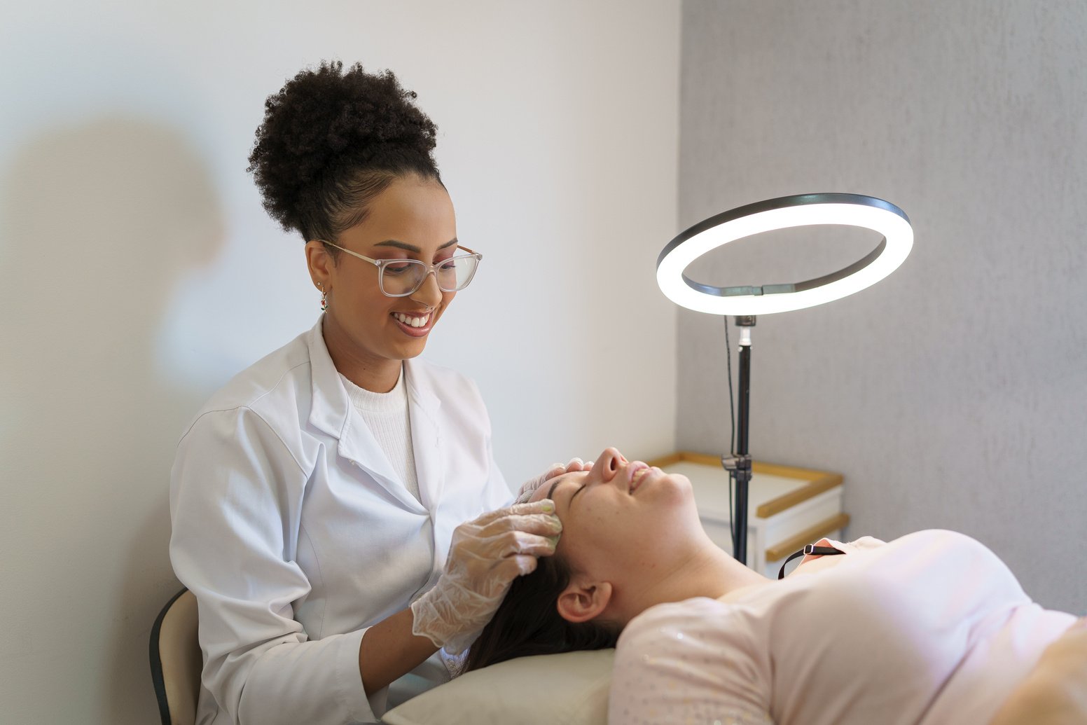 Esthetician performing skin cleansing on client